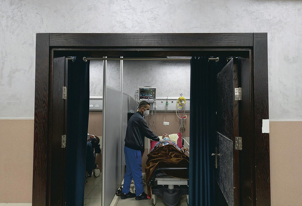 A medical staffer attends a Palestinian patient infected with COVID-19 at the emergency unit, of the Palestine Medical Complex, in the West Bank city of Ramallah, Tuesday, March 2, 2021. (AP Photo/Nasser Nasser)
