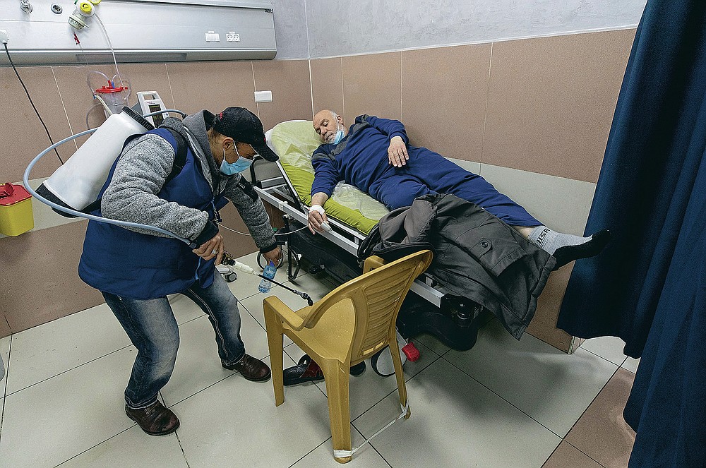 A Palestinian medical staffer sterilizes a room occupied by a COVID-19 patient who is under medical observation, at the emergency unit, of the Palestine Medical Complex, in the West Bank city of Ramallah, Tuesday, March 2, 2021. (AP Photo/Nasser Nasser)