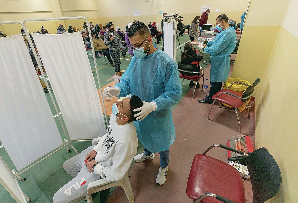 Health care workers take nasal swab samples from Palestinians at a COVID-19 testing center, in the Palestine Medical Complex, in the West Bank city of Ramallah, Tuesday, March 2, 2021. (AP Photo/Nasser Nasser)