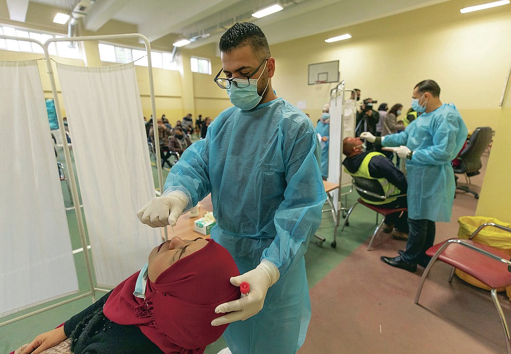 Health care workers take nasal swab samples from Palestinians at a COVID-19 testing center, in the Palestine Medical Complex, in the West Bank city of Ramallah, Tuesday, March 2, 2021. (AP Photo/Nasser Nasser)