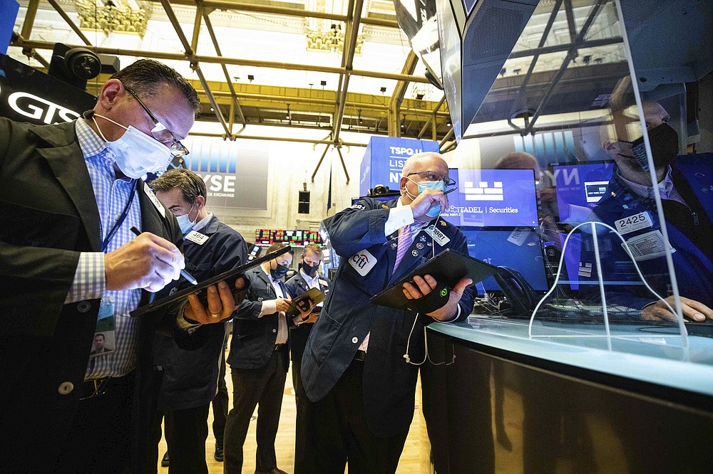 In this photo provided by the New York Stock Exchange, Thomas Ferrigno, center, and fellow traders work with specialist Meric Greenbaum, right, on the floor, Tuesday, March 2, 2021, in New York. Stocks are drifting lower in afternoon trading on Wall Street Tuesday, giving back some of their big gains from a day earlier. (Colin Ziemer/New York Stock Exchange via AP)