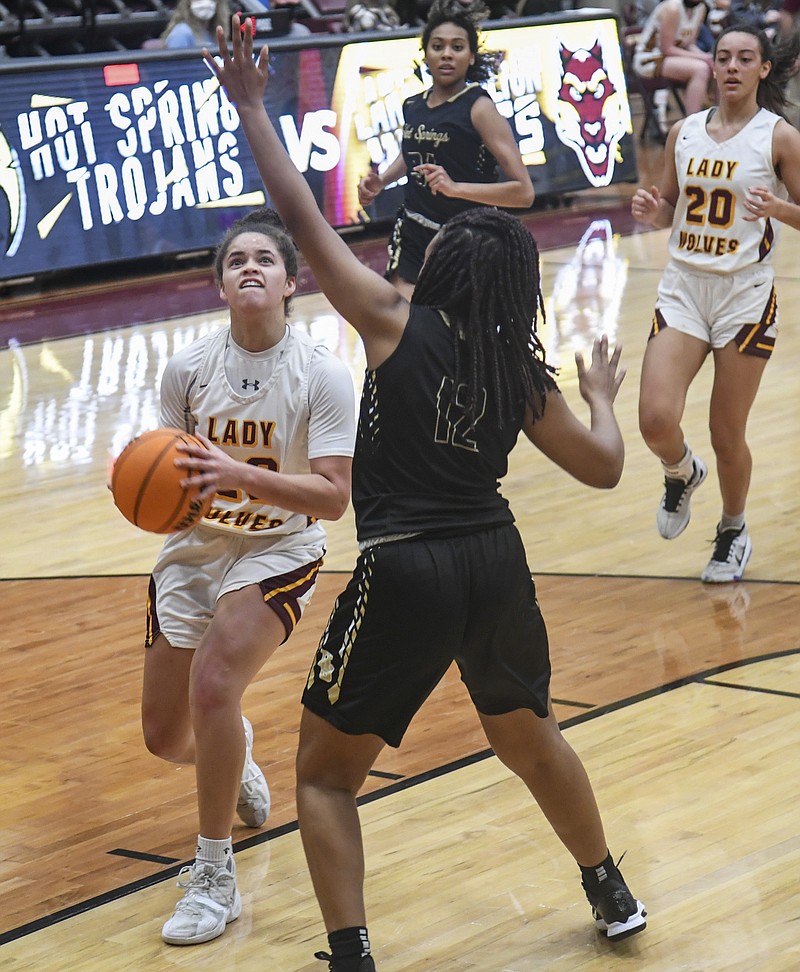 Lake Hamilton's Hayleigh Wyrick (23) drives in for a shot as Hot Springs' KaLariya McDaniel (12) looks to block in Tuesday's game at Wolf Arena. The Lady Wolves won 56-34. - Photo by Grace Brown of The Sentinel-Record