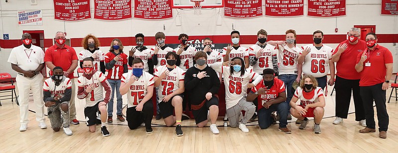 The Mountain Pine High School football team display their state championship rings following a ceremony at the school Wednesday. The 2020 Red Devils football team won the 2020 2A Eight-Man Football state championship in November. - Photo by Richard Rasmussen of The Sentinel-Record