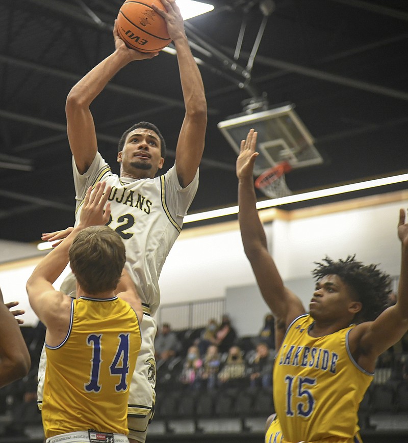 Hot Springs' Jabari West (32) goes up for a shot as Lakeside's Logan White (14) and Alveon Harris (15) defend during Wednesday's game at Trojan Arena. - Photo by Grace Brown of The Sentinel-Record