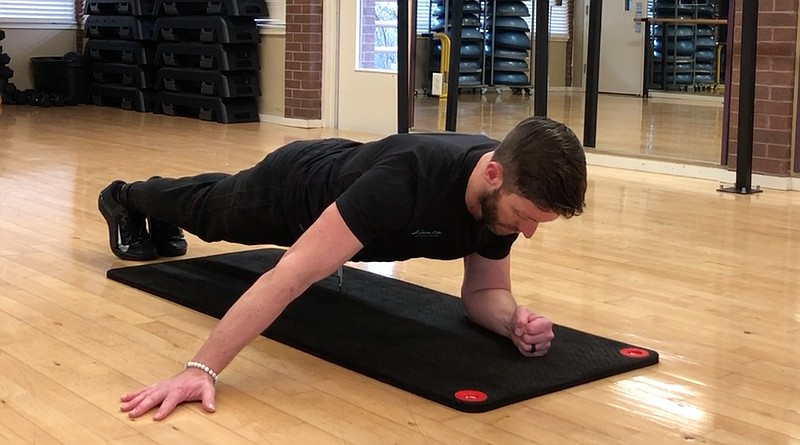 Josh Holt, fitness director at Little Rock Racquet Club, does the Archer Bodyweight Skull Crusher without slipping and crushing his skull. (Arkansas Democrat-Gazette/Celia Storey)