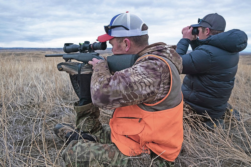 CORRECTS DATE TO JAN. 17, 2021 Brian Meyer uses his prosthetic leg as a gun rest while waiting for a shot on a bison during a bison hunt on the American Prairie Reserve in northeastern Montana on Jan. 17, 2021. A love of hunting propelled the 39-year-old Meyer to the remote prairie of Eastern Montana. Wounded Warriors Outdoors arranged for Meyer to participate in a donated bison harvest on land owned by American Prairie Reserve. (Thom Bridge/Independent Record via AP)