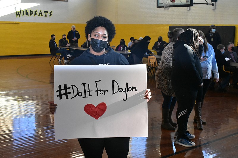 Jamie Gordon, an eighth-grade science teacher at Watson Chapel Junior High School, holds up a hashtag sign in honor of slain student Daylon Burnett, 15, during an assembly Thursday on campus. Burnett died Wednesday from injuries sustained in an on-campus shooting two days earlier. (Pine Bluff Commercial/I.C. Murrell)