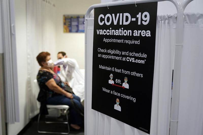 The Associated Press
In this March 1 file photo, a patient receives a shot of the Moderna COVID-19 vaccine next to a guidelines sign at a CVS Pharmacy branch in Los Angeles.