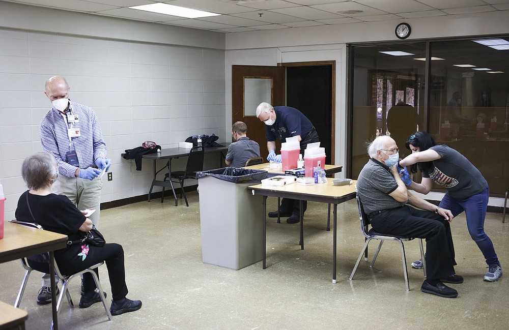 Volunteers administers covid-19 vaccines to people, Thursday, March 4, 2021 at Riordan Hall in Bella Vista. The Bella Vista Fire Department with the help of volunteers held a vaccine clinic for people in Phase 1-B. They planned 1,200 first doses for the one-day event. Check out nwaonline.com/210305Daily/ for today's photo gallery.
(NWA Democrat-Gazette/Charlie Kaijo)