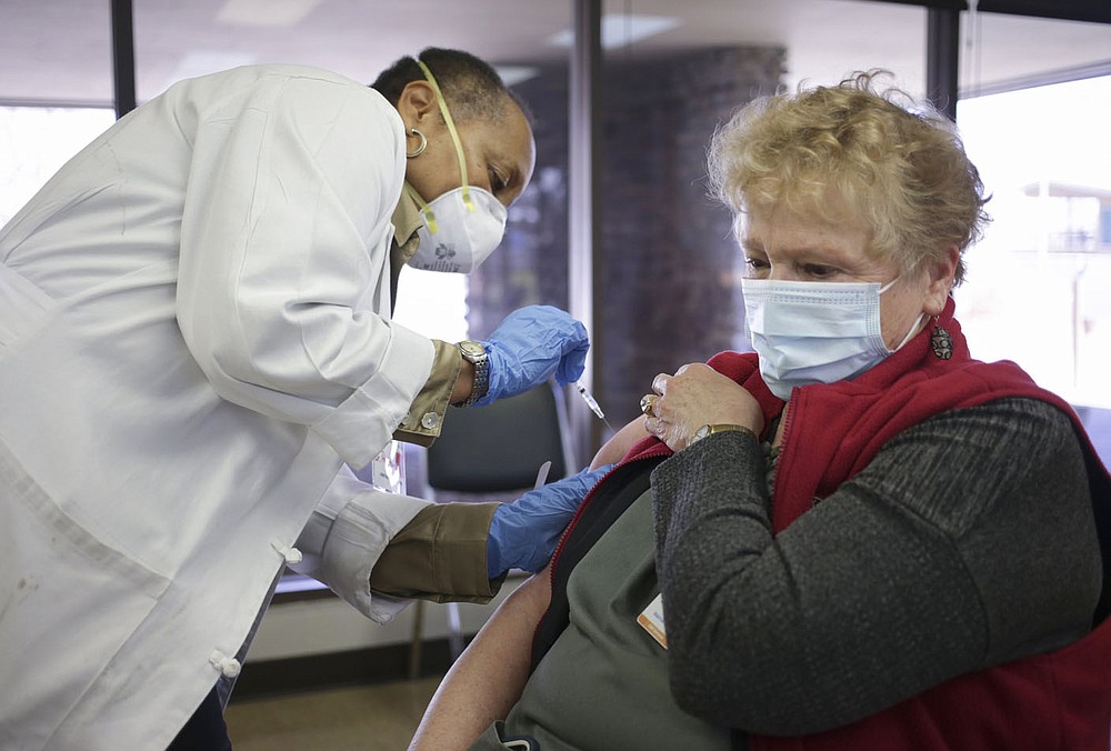 Dr. Glenda Patterson (from left) administers a covid-19 vaccine to Care Butler of Bella Vista, Thursday, March 4, 2021 at Riordan Hall in Bella Vista. The Bella Vista Fire Department with the help of volunteers held a vaccine clinic for people in Phase 1-B. They planned 1,200 first doses for the one-day event.(NWA Democrat-Gazette/Charlie Kaijo)