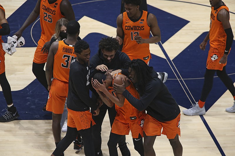 Oklahoma State guard Avery Anderson III, center, celebrates after defeating West Virginia in Saturday's game in Morgantown, W.Va. - Photo by Kathleen Batten of The Associated Press