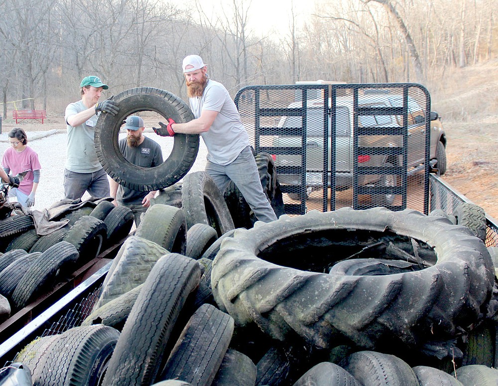 Keith Bryant/The Weekly Vista Marykate Bertalotto, left, background, helps stack tires along with Michael Beilfuss, Joshua James and Trey Ansom during a trailside tire cleanup last Thursday afternoon.