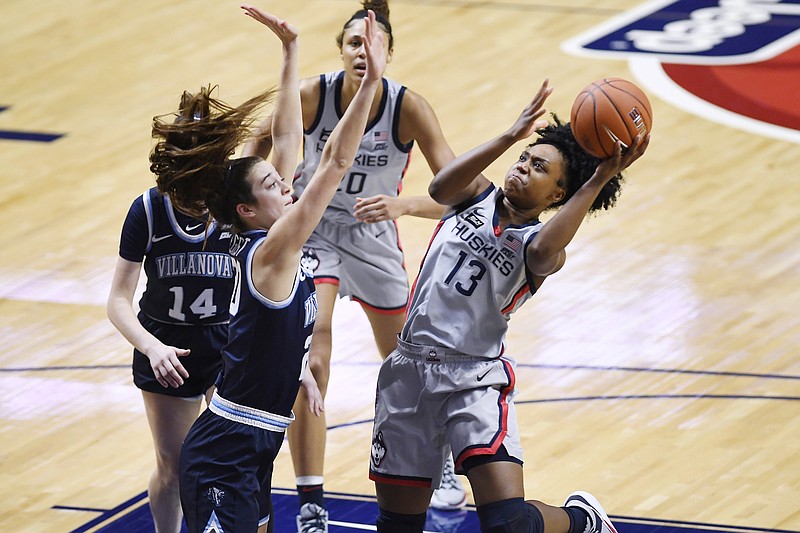 Connecticut's Christyn Williams, right, goes up for a basket as Villanova's Maddy Siegrist, front left, defends during the first half of an NCAA college basketball game in the Big East tournament semifinals at Mohegan Sun Arena, Sunday, March 7, 2021, in Uncasville, Conn. (AP Photo/Jessica Hill)