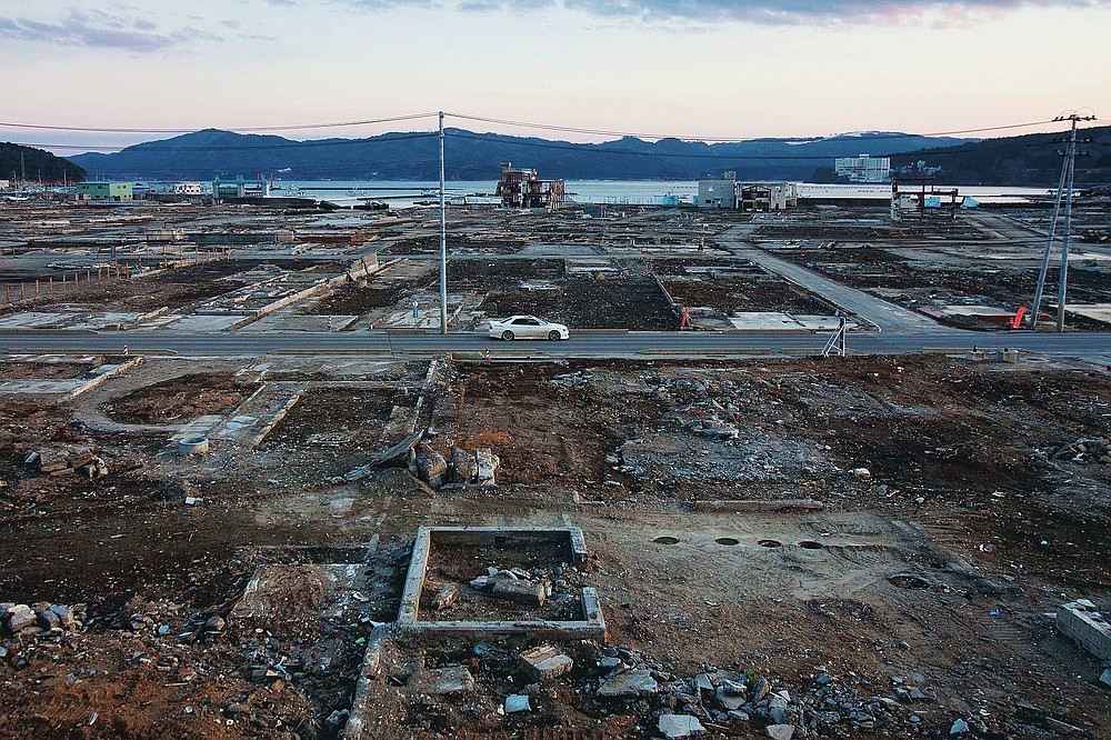 In this file photo dated February 23, 2012, almost a year after the March 11 tsunami, a car drives through the flat town of Minamisanriku in Miyagi Prefecture in northeastern Japan.  (AP Photo / David Guttenfelder, file)