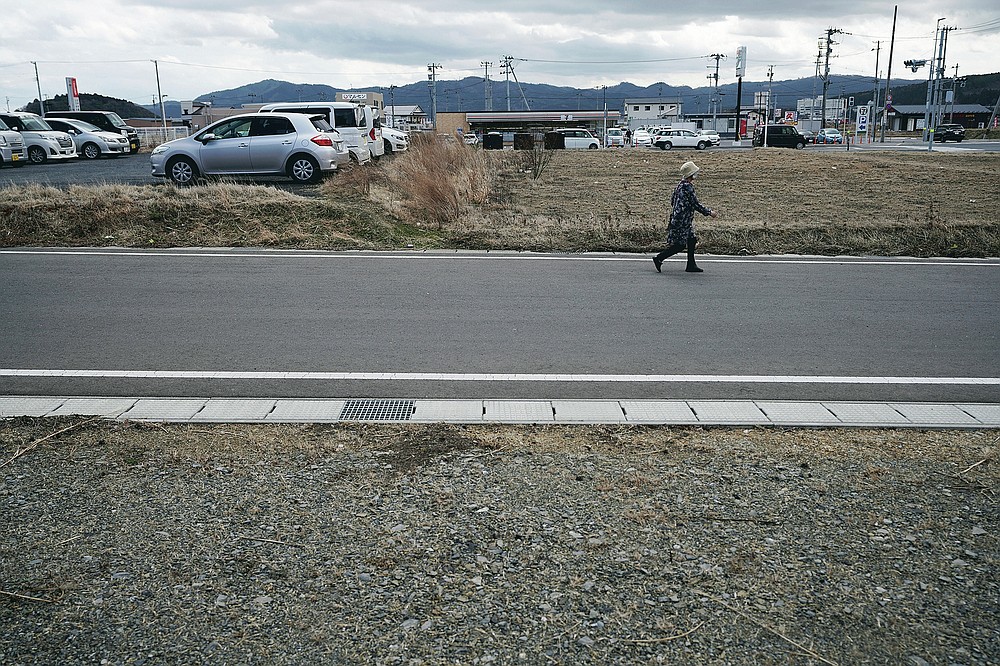 A woman walks through the city of Minamisanriku in Miyagi Prefecture in northern Japan on Saturday, March 6, 2021, almost ten years after the tsunami.  (AP Photo / Eugene Hoshiko)