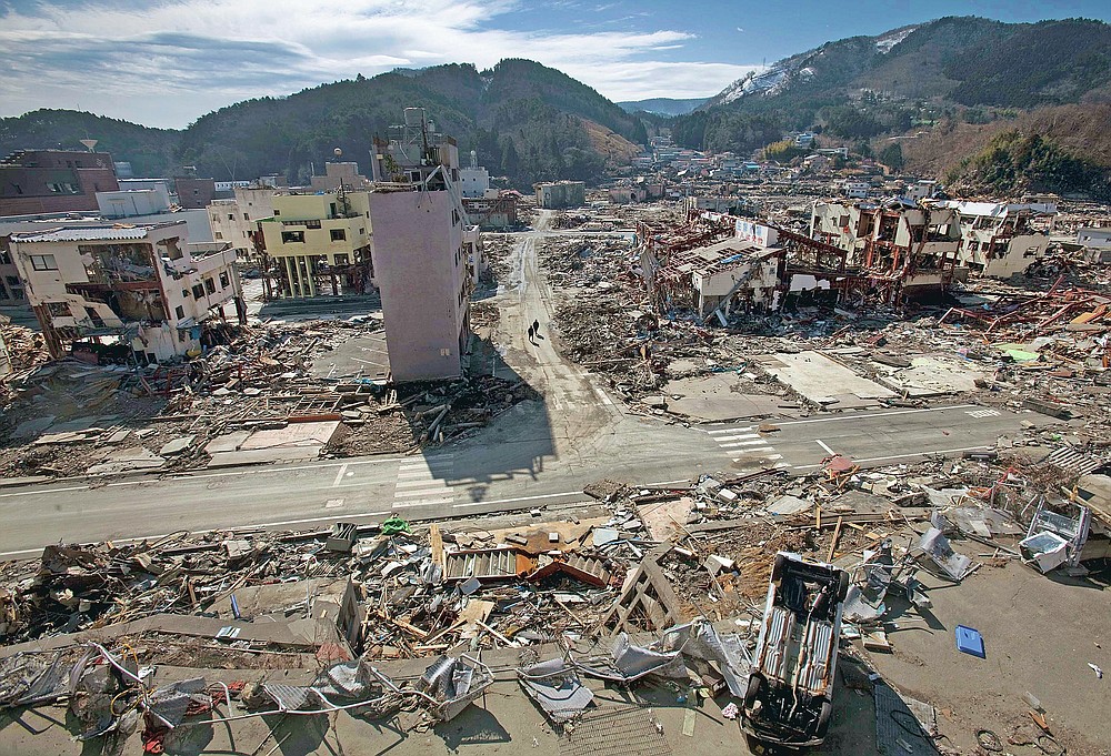 In this file photo dated March 19, 2011, residents of the tsunami and earthquake that destroyed the city of Onagawa, Miyagi Prefecture, northern Japan, walk down an empty street.  (AP Photo / David Guttenfelder, file)