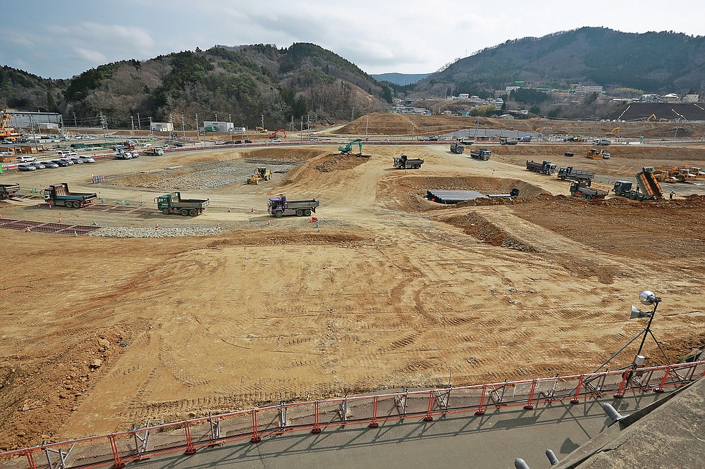 In this file photo dated March 5, 2016, trucks are queuing to dump soil in the tsunami and the earthquake-devastated city of Onagawa, Miyagi Prefecture, northern Japan.  (AP Photo / Eugene Hoshiko, File)