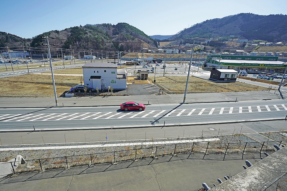Ten years after the disaster, some new buildings are sparse in the tsunami and earthquake-destroyed city of Onagawa in Miyagi Prefecture in northern Japan.  Thursday March 4, 2021. (AP Photo / Eugene Hoshiko)