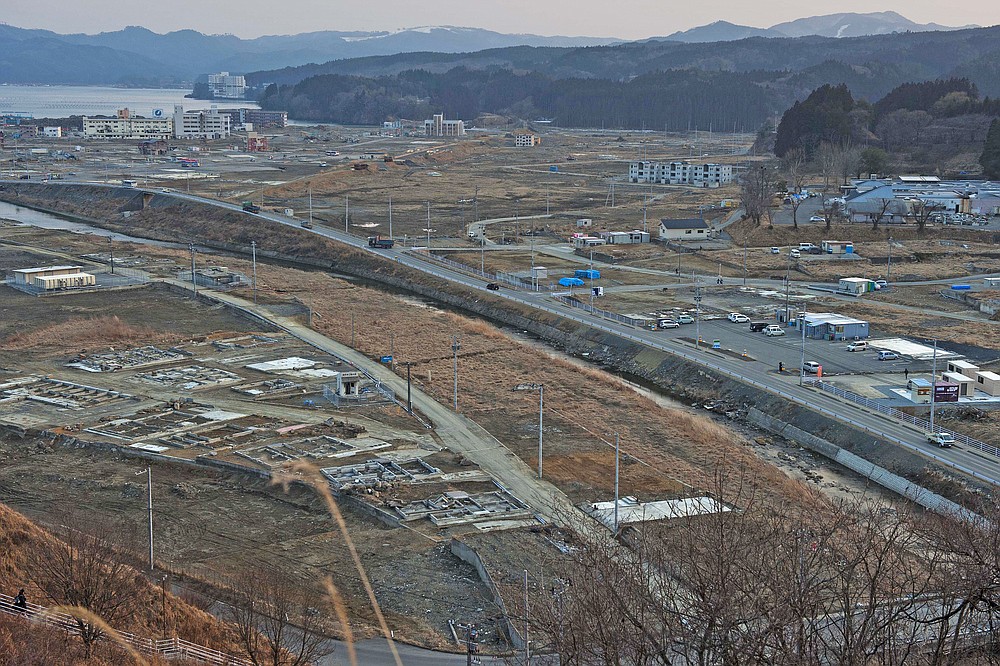 In this file photo dated February 23, 2012, almost a year after the March 11, 2011 tsunami, vehicles are driving through the ruins of the flat city of Minamisanriku in Miyagi Prefecture in northern Japan.  (AP Photo / David Guttenfelder, file)