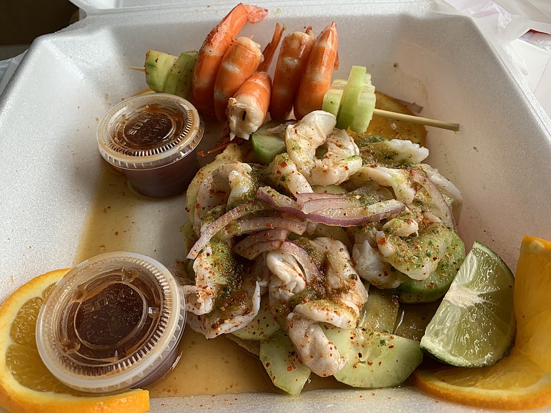 The Tostada La Patrona from Mariscos “La Corita” Nayarit features plenty of shrimp — peel-and-eat on a skewer and a pile of ceviche — with plenty of cucumber. (Arkansas Democrat-Gazette/Eric E. Harrison)