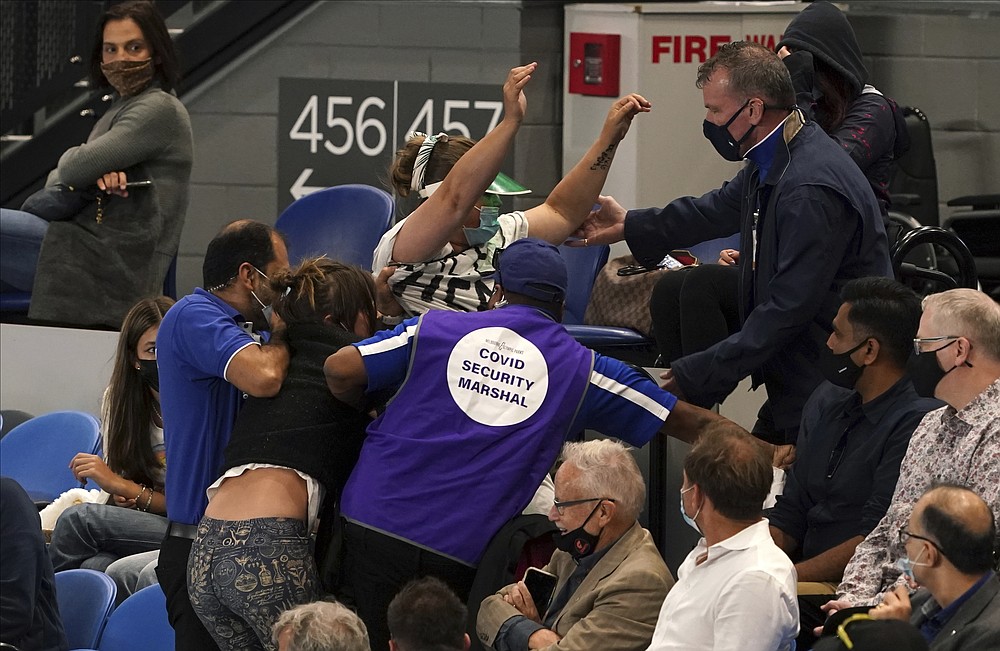 FILE - Women are ejected by security during the men's singles final match between Serbia's Novak Djokovic and Russia's Daniil Medvedev on Rod Laver Arena at the Australian Open tennis championship in Melbourne, Australia, in this Sunday, Feb. 21, 2021, file photo. (AP Photo/Mark Dadswell)