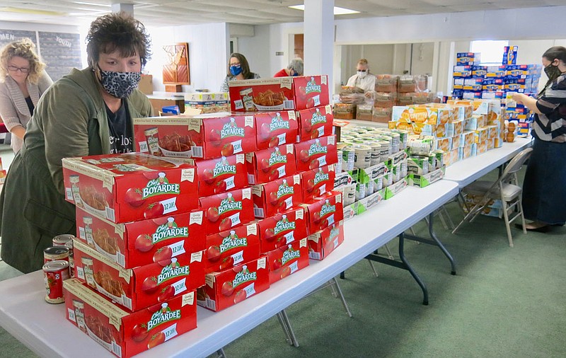 Westside Eagle Observer/SUSAN HOLLAND
Heather Finley (left foreground), president of Gravette Bright Futures, prepares to unbox cans of ravioli to be used in filling backpacks for Gravette schools' students during spring break. Bright Futures members, assisted by members of the Gravette Lions Club, filled 132 backpacks Tuesday morning, March 9. Other workers visible in the background are Dawn Maddox, Lisa Singleton, Sue Rice, Snooky Garrett and Alexis Frizzell.