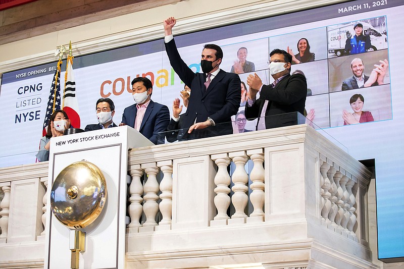 In this photo provided by the New York Stock Exchange, Coupang Founder and CEO Bom Kim, third left, and his colleagues, joined by John Tuttle, NYSE Vice Chairman, second from right, rings the NYSE opening before his company's IPO, Thursday March 11, 2021.The biggest IPO in years is rolling out Thursday on the NYSE where Coupang, the South Korean equivalent of Amazon in the U.S., or Alibaba in China, will begin trading under the ticker "CPNG." (Courtney Crow/New York Stock Exchange via AP)