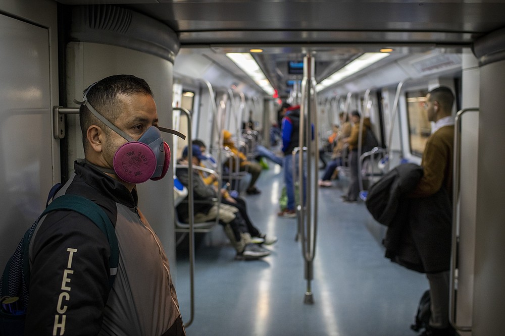 FILE - In this Wednesday, March 18, 2020 file photo, a man wearing a face mask to prevent the spread of coronavirus travels by train in Barcelona, Spain. When the World Health Organization declared the coronavirus a pandemic one year ago Thursday, March 11 it did so only after weeks of resisting the term and maintaining the highly infectious virus could still be stopped. A year later, the U.N. agency is still struggling to keep on top of the evolving science of COVID-19, to persuade countries to abandon their nationalistic tendencies and help get vaccines where they’re needed most. (AP Photo/Emilio Morenatti, file)