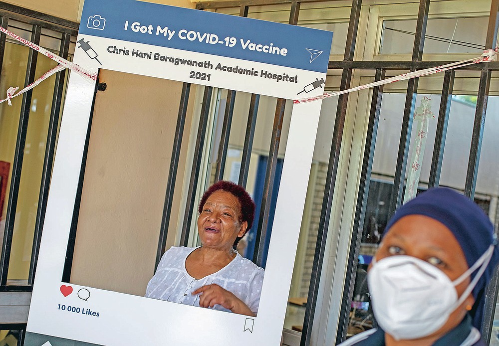 Maggie Sedidi, a 59-year-old nurse at Soweto's Chris Hani Baragwanath hospital, poses for a photo taken by a colleague after receiving her dose of the Johnson & Johnson COVID-19 vaccine from a health staff member at a vaccination center in Soweto, South Africa, Friday, March 5, 2021. Sedidi is optimistic: "By next year, or maybe the year after, I really do hope that people will be able to begin returning to normal life." (AP Photo/Themba Hadebe)
