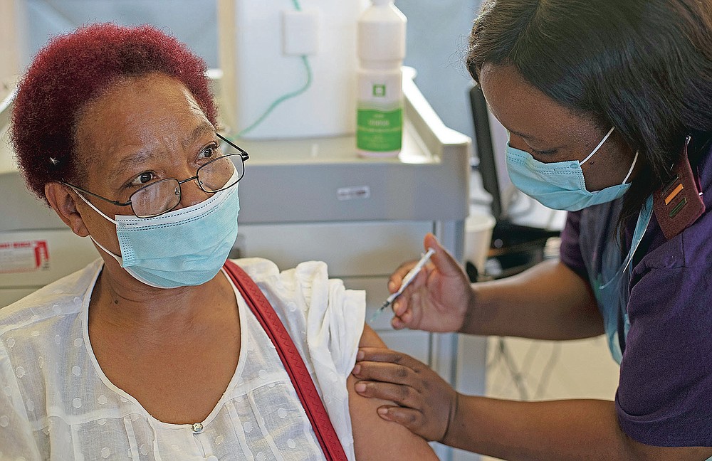 Maggie Sedidi, a 59-year-old nurse at Soweto's Chris Hani Baragwanath hospital, receives the Johnson & Johnson COVID-19 vaccine from a health staff member at a vaccination center in Soweto, South Africa, Friday, March 5, 2021. Sedidi is optimistic: "By next year, or maybe the year after, I really do hope that people will be able to begin returning to normal life." (AP Photo/Themba Hadebe)