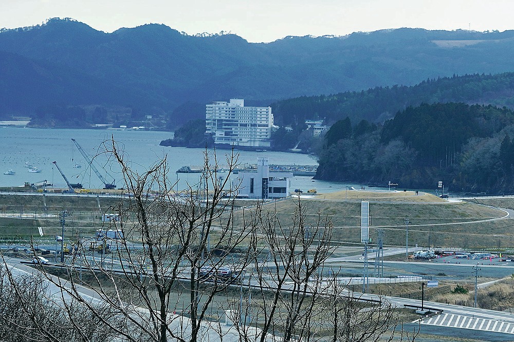 A former wedding ceremony hall "Takano Kaikan," center, ruined by the 2011 deadly tsunami is seen in Minamisanriku, Miyagi Prefecture, northern Japan Saturday, March 6, 2021. When the tsunami struck the town, around 300 senior citizens evacuated to a room on the top floor and a machinery room on the roof to survived. (AP Photo/Eugene Hoshiko)