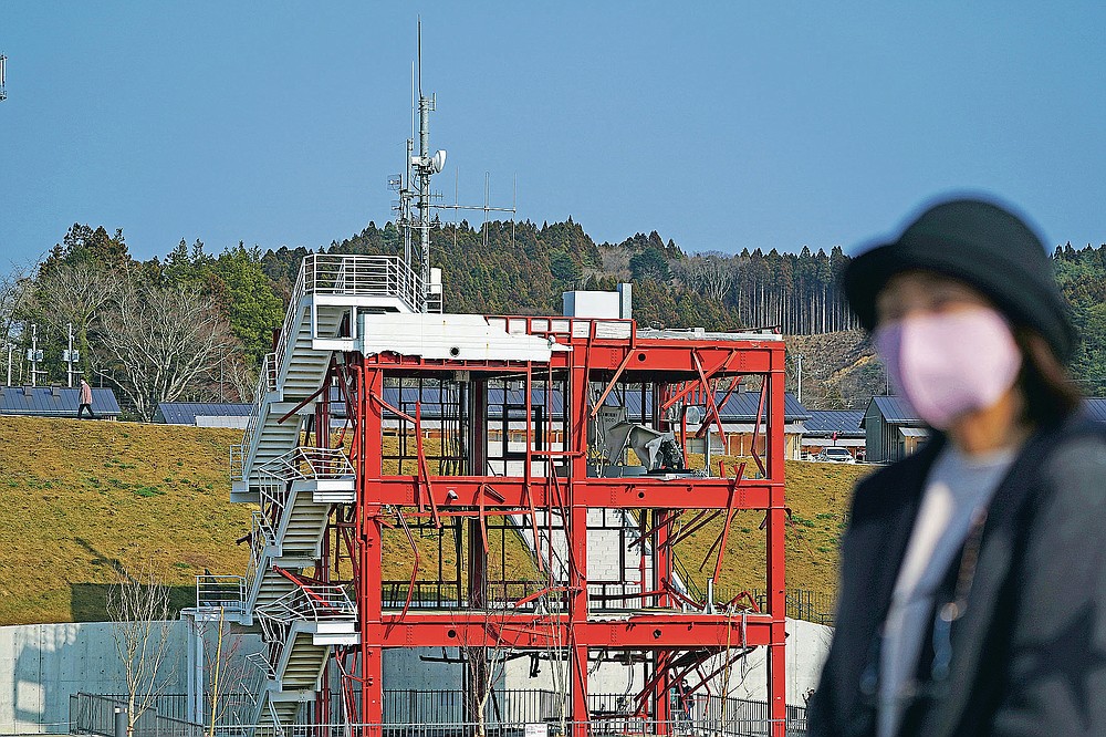 The skeleton of the tsunami-damaged disaster prevention headquarters where 43 workers died as the 2011 tsunami washed over it, is seen in Minamisanriku, Miyagi Prefecture, northern Japan, Saturday, March 6, 2021. The three-story building is one of legacies that still stand in northern Japan's coastal towns, 10 years after the earthquake and tsunami that killed more than 18,000 people. (AP Photo/Eugene Hoshiko)
