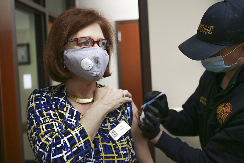 Bentonville Fire Department Paramedic Josh Davis (right) administers a covid-19 vaccine to City Council member Cindy Acree (left), Friday at the Bentonville City Hall in Bentonville. The Bentonville Fire Department administered 150 vaccines to city employees at various city properties in Bentonville. Check out nwaonline.com/210312Daily/ for today's photo gallery. 
(NWA Democrat-Gazette/Charlie Kaijo)