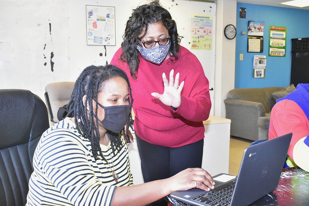 Pine Bluff High School Principal Claudette White, right, waves to a virtual learning student as physical science instructor Carman Wilson teaches a class Wednesday. (Pine Bluff Commercial/I.C. Murrell)