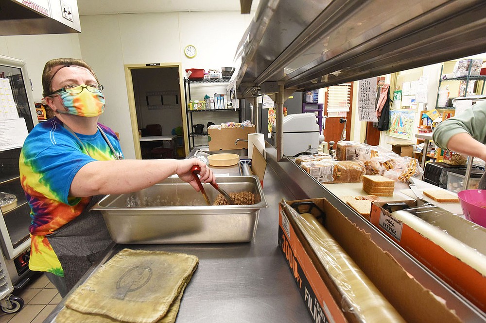 Becky Holt cooks lunch in the kitchen on Wednesday March 17 2021 at the Benton County Sunshine School and Development Center.
(NWA Demorcrat-Gazette/Flip Putthoff)