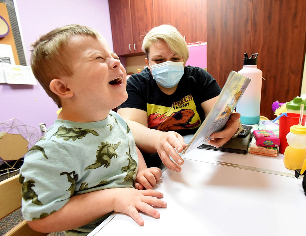 Tabitha Mayberry, speech therapist, and her student laugh together on Wednesday March 17 2021 while reading a story at the Benton County Sunshine School and Development Center in Rogers.
(NWA Democrat-Gazette/Flip Putthoff)