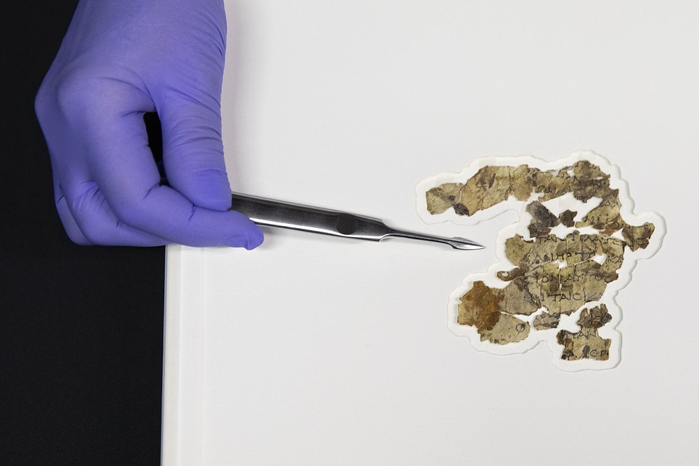 Israel Antiquities Authority conservator Tanya Bitler shows newly discovered Dead Sea Scroll fragments at the Dead Sea scrolls conservation lab in Jerusalem, Tuesday, March 16, 2021. Israeli archaeologists on Tuesday announced the discovery of dozens of new Dead Sea Scroll fragments bearing a biblical text found in a desert cave and believed hidden during a Jewish revolt against Rome nearly 1,900 years ago. (AP Photo/Sebastian Scheiner)