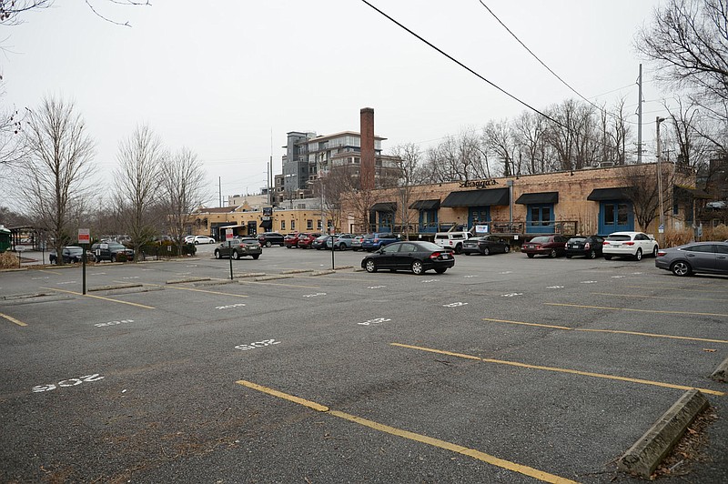 Vehicles are parked in January 2020 in a parking lot near Arsaga's at the Depot in Fayetteville. The City Council on Tuesday accepted a contract dealing with the land and development of a new parking deck in the location.
(File photo/NWA Democrat-Gazette/Andy Shupe)