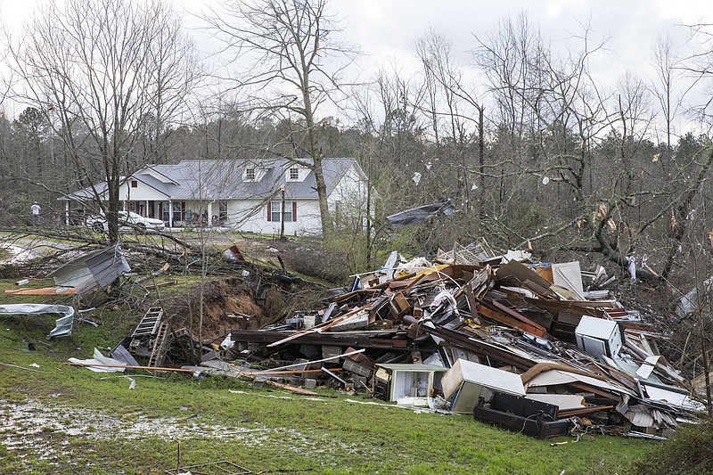 Debris litters weather-damaged properties at the intersection of County Road 24 and 37 in Clanton, Ala., the morning following a large outbreak of severe storms across the southeast, Thursday, March 18, 2021. (AP Photo/Vasha Hunt)