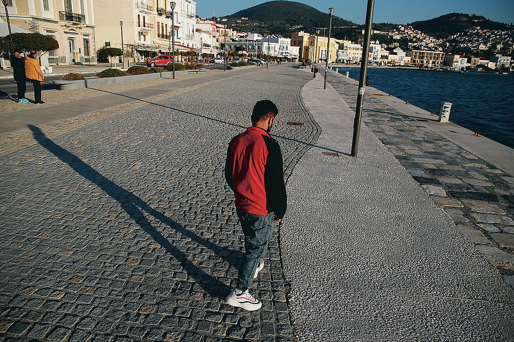 An Afghan father walks, at the port of Vathy on the eastern Aegean island of Samos, Greece, Monday, Feb. 22, 2021. On a hill above a small island village, the sparkling blue of the Aegean just visible through the pine trees, lies a boy’s grave. His first ever boat ride was to be his last - the sea claimed him before his sixth birthday. His 25-year-old father, like so many before him, had hoped for a better life in Europe, far from the violence of his native Afghanistan. But his dreams were dashed on the rocks of Samos, a picturesque Greek island almost touching the Turkish coast. Still devastated from losing his only child, the father has now found himself charged with a felony count of child endangerment. (AP Photo/Thanassis Stavrakis)