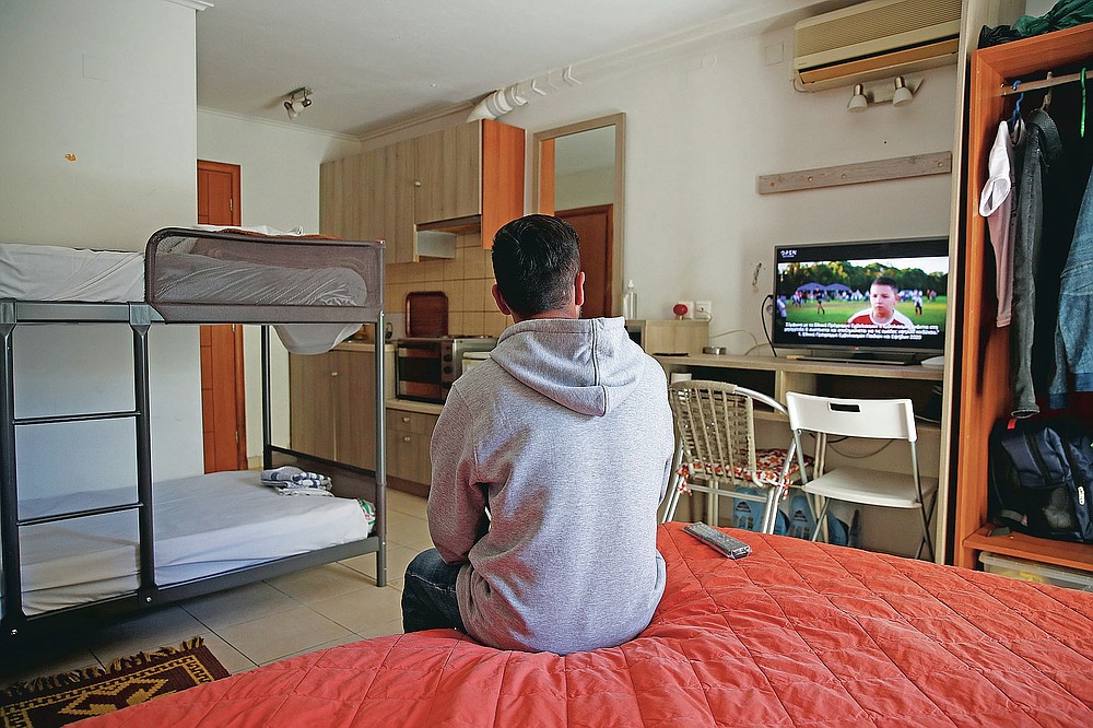 An Afghan father watches television in his room, at the port of Vathy on the eastern Aegean island of Samos, Greece, Wednesday, Feb. 24, 2021. On a hill above a small island village, the sparkling blue of the Aegean just visible through the pine trees, lies a boy’s grave. His first ever boat ride was to be his last - the sea claimed him before his sixth birthday. His 25-year-old father, like so many before him, had hoped for a better life in Europe, far from the violence of his native Afghanistan. But his dreams were dashed on the rocks of Samos, a picturesque Greek island almost touching the Turkish coast. Still devastated from losing his only child, the father has now found himself charged with a felony count of child endangerment. (AP Photo/Thanassis Stavrakis)