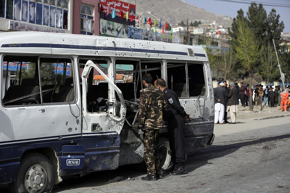 Le personnel de sécurité inspecte un minibus endommagé après l'explosion d'une bombe à Kaboul, en Afghanistan, le jeudi 18 mars 2021. L'attaque du bus a fait de nombreux morts et blessés selon la police.  (Photo AP / Mariam Zuhaib)