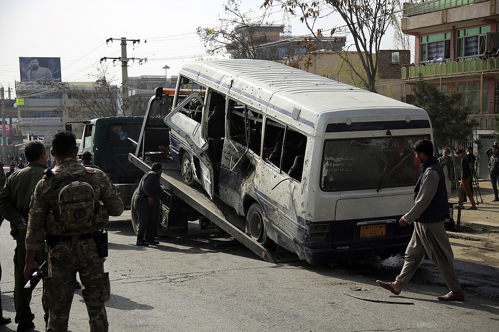 Le personnel de sécurité enlève un minibus endommagé après l'explosion d'une bombe à Kaboul en Afghanistan, le jeudi 18 mars 2021. L'attaque du bus a fait de nombreux morts et blessés selon la police.  (Photo AP / Mariam Zuhaib)