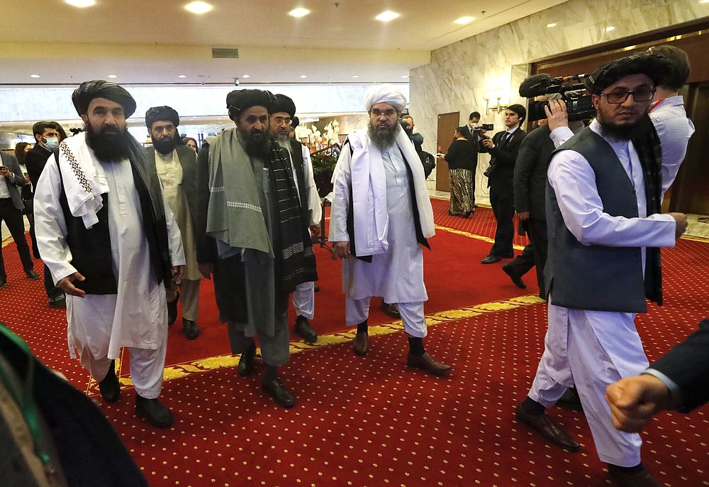 Taliban co-founder Mullah Abdul Ghani Baradar, centre, arrives with other members of the Taliban delegation for attending an international peace conference in Moscow, Russia, Thursday, March 18, 2021. Russia is hosting a peace conference for Afghanistan, bringing together government representatives and their Taliban adversaries along with regional observers in a bid to help jump-start the country's stalled peace process. The one-day gathering Thursday is the first of three planned international conferences ahead of a May 1 deadline for the final withdrawal of U.S. and NATO troops from the country, a date fixed under a year-old agreement between the Trump administration and the Taliban. (AP Photo/Alexander Zemlianichenko, Pool)