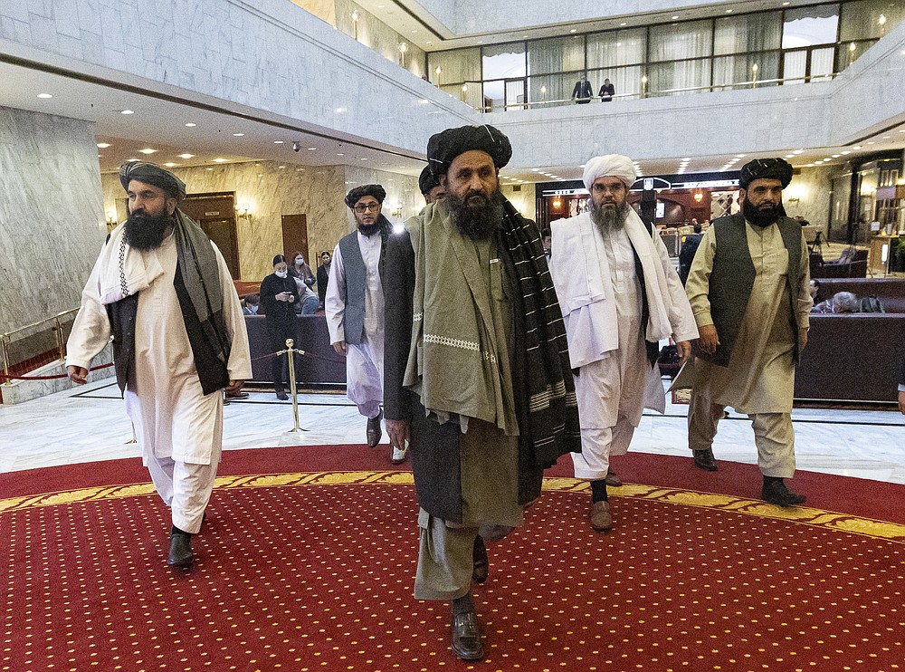 Taliban co-founder Mullah Abdul Ghani Baradar, center, arrives with other members of the Taliban delegation for an international peace conference in Moscow, Russia, Thursday, March 18, 2021. Russia is hosting a peace conference for Afghanistan, bringing together government representatives and their Taliban adversaries along with regional observers in a bid to help jump-start the country's stalled peace process. The one-day gathering Thursday is the first of three planned international conferences ahead of a May 1 deadline for the final withdrawal of U.S. and NATO troops from the country, a date fixed under a year-old agreement between the Trump administration and the Taliban. (AP Photo/Alexander Zemlianichenko, Pool)