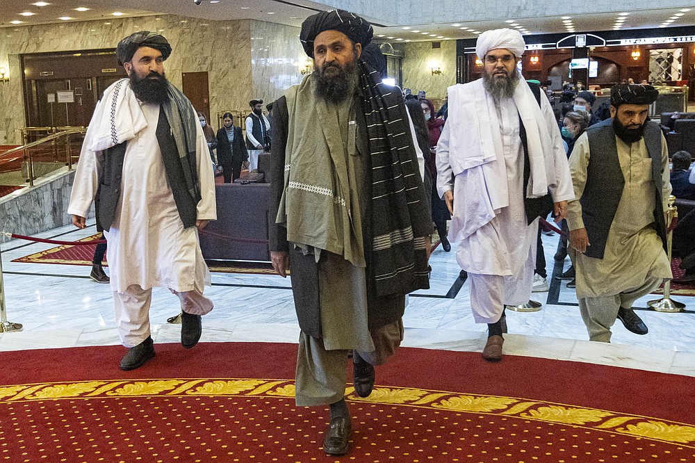 Taliban co-founder Mullah Abdul Ghani Baradar, center, arrives with other members of the Taliban delegation for an international peace conference in Moscow, Russia, Thursday, March 18, 2021. Russia is hosting a peace conference for Afghanistan, bringing together government representatives and their Taliban adversaries along with regional observers in a bid to help jump-start the country's stalled peace process. The one-day gathering Thursday is the first of three planned international conferences ahead of a May 1 deadline for the final withdrawal of U.S. and NATO troops from the country, a date fixed under a year-old agreement between the Trump administration and the Taliban. (AP Photo/Alexander Zemlianichenko, Pool)