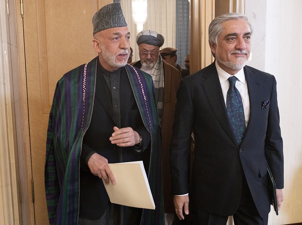 Former Afghan President Hamid Karzai, left, and former Foreign Affairs Minister Abdullah Abdullah leave the hall of an international peace conference in Moscow, Russia, Thursday, March 18, 2021. Russia is hosting a peace conference for Afghanistan, bringing together government representatives and their Taliban adversaries along with regional observers in a bid to help jump-start the country's stalled peace process. The one-day gathering Thursday is the first of three planned international conferences ahead of a May 1 deadline for the final withdrawal of U.S. and NATO troops from the country, a date fixed under a year-old agreement between the Trump administration and the Taliban. (AP Photo/Alexander Zemlianichenko, Pool)