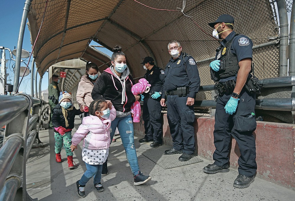 FILE - In this Friday, Feb. 26, 2021 file photo, a migrant family wearing face masks crosses the border into El Paso, Texas, in Ciudad Juarez, Mexico. On Friday, March 18, 2021, The Associated Press reported on stories circulating online incorrectly asserting that President Joe Biden is not screening immigrants for COVID-19 at the border and is allowing “everyone in no matter what.” In fact, February data from U.S. Customs and Border Protection shows the Biden administration has continued to use an existing public health rule, known as Title 42, to immediately expel more than 70 percent of asylum seekers and border crossers stopped at the border. (AP Photo/Christian Chavez)