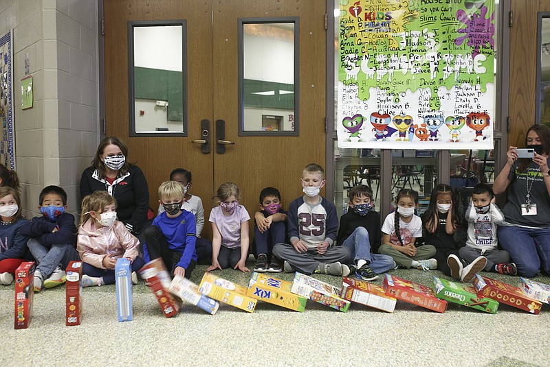 Students watch as cereal boxes topple, Friday at Bellview Elementary School in Rogers. Several Rogers schools are helping the Samaritan Center by collecting boxes of cereal to feed the hungry. Bellview filled their halls with cereal boxes to create a domino effect. Check out nwaonline.com/210320Daily/ for today's photo gallery. 
(NWA Democrat-Gazette/Charlie Kaijo)