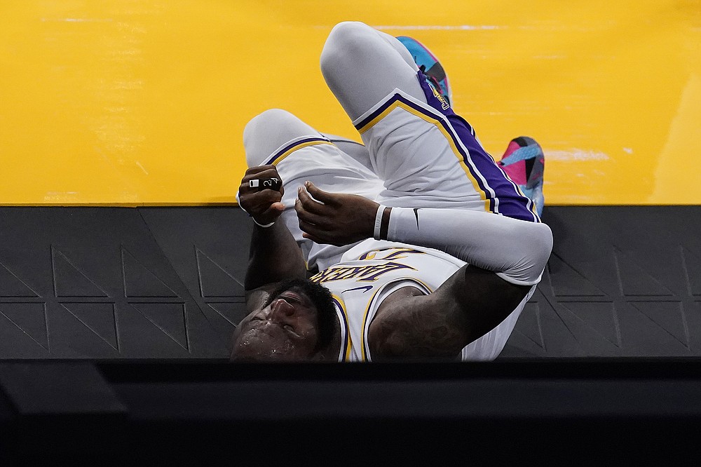 Los Angeles Lakers forward LeBron James rolls off the court after going down with an injury during the first half of an NBA basketball game against the Atlanta Hawks Saturday, March 20, 2021, in Los Angeles. (AP Photo/Marcio Jose Sanchez)